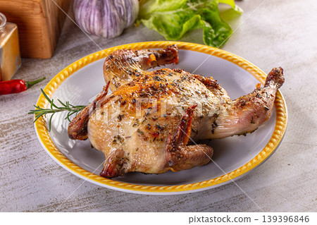 Gourmet roasted whole quail seasoned with herbs on a rustic kitchen table. Gourmet roasted whole quail seasoned with herbs on a rustic kitchen table. 139396846