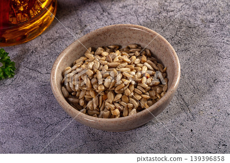 Shelled sunflower seeds in a ceramic bowl on a gray textured background Shelled sunflower seeds in a ceramic bowl on a gray textured background 139396858