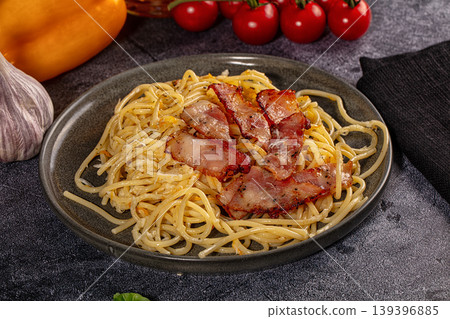 Spaghetti carbonara with crispy bacon and fresh ingredients on dark background Spaghetti carbonara with crispy bacon and fresh ingredients on dark background 139396885