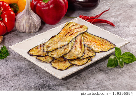 Grilled eggplant slices on white plate with fresh vegetables and herbs Grilled eggplant slices on white plate with fresh vegetables and herbs 139396894