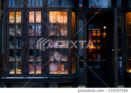 Warm vintage cupboard displaying antique porcelain dishes in an entrance hall 139397166