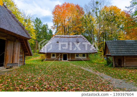 Traditional Ukrainian village with thatched roof houses in vibrant autumn foliage Traditional Ukrainian village with thatched roof houses in vibrant autumn foliage 139397604