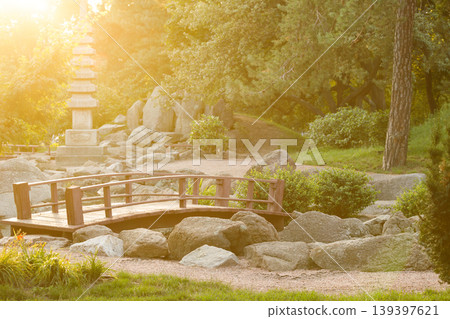 bright vivid Japanese style garden with wooden bridge and stone pagoda at sunrise bright vivid Japanese style garden with wooden bridge and stone pagoda at sunrise 139397621