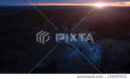 Romantic twilight aerial landscape with sunset glare over a spooky swamp and countryside Romantic twilight aerial landscape with sunset glare over a spooky swamp and countryside 139397631