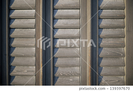 Aged horizontal wooden louvers background featuring a weathered wooden texture suitable for architectural or design projects. Aged horizontal wooden louvers background featuring a weathered wooden texture suitable for architectural or design projects. 139397670
