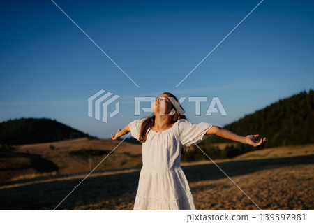 Rear view of a beautiful little girl feeling free in summer in nature. 139397981