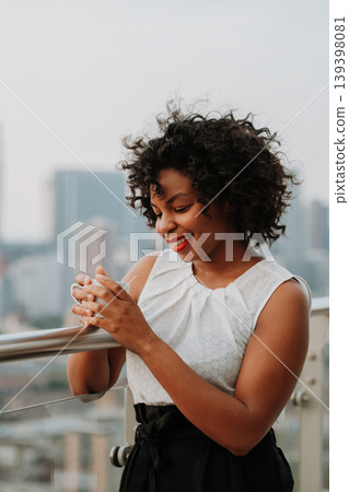Portrait of a businesswoman drinking coffee on terrace of modern office. Portrait of a businesswoman drinking coffee on terrace of modern office. 139398081