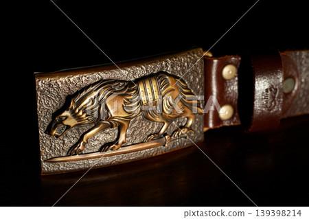 Ornate wolf iron forged male clasp for belt with textured background Ornate wolf iron forged male clasp for belt with textured background 139398214