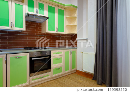 Modern kitchen interior with green cabinets and brown brick backsplash Modern kitchen interior with green cabinets and brown brick backsplash 139398250