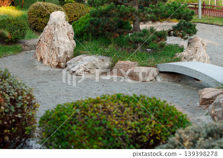 Serene Japanese garden with raked gravel, rocks, and a small arched bridge Serene Japanese garden with raked gravel, rocks, and a small arched bridge 139398278