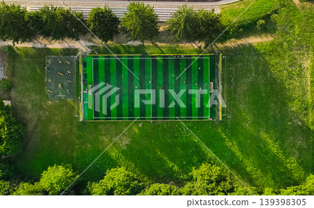 Aerial view of a rustic football field with players and outdoor gym equipment nearby Aerial view of a rustic football field with players and outdoor gym equipment nearby 139398305