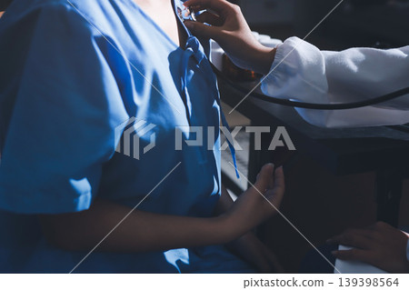 healthy concept; Doctor checking patient's heart with stethoscope at a hospital healthy concept; Doctor checking patient's heart with stethoscope at a hospital 139398564