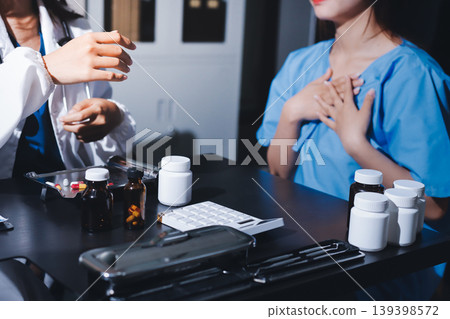 Female doctor holding a medicine bottle is checking the quality of medicine for any side effects the patient or not and recording patient information at the hospital. medical and health care concept Female doctor holding a medicine bottle is checking the quality of medicine for any side effects the patient or not and recording patient information at the hospital. medical and health care concept 139398572