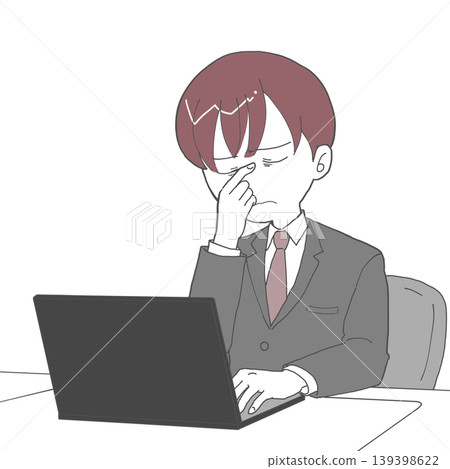 A man wiping the corner of his eye while working at his desk. 139398622