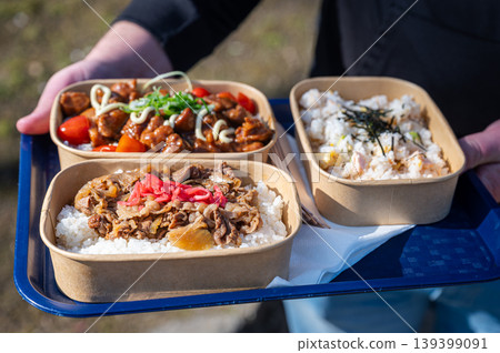 City resident swiftly retrieves freshly prepared bento box from nearby street vendor City resident swiftly retrieves freshly prepared bento box from nearby street vendor 139399091