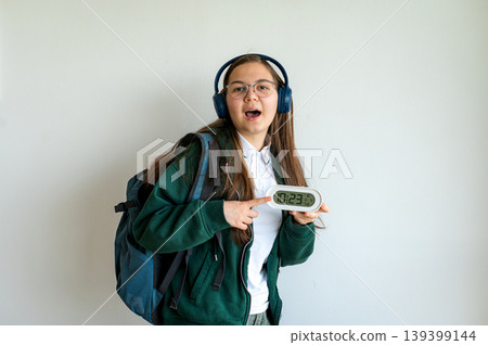 Teenage student holding a clock on white background Teenage student holding a clock on white background 139399144