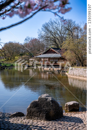 Japanese spring landscape scene. Calm waters reflecting pavilion surrounded by rocky shoreline Japanese spring landscape scene. Calm waters reflecting pavilion surrounded by rocky shoreline 139399197