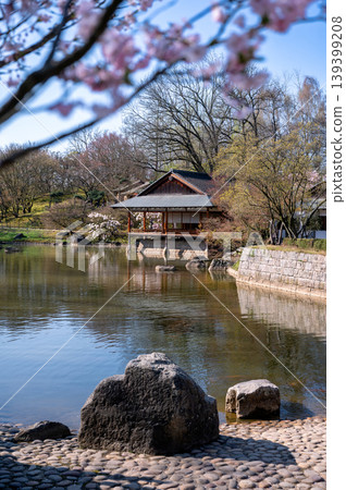 Wide panoramic view capturing harmonious Japanese garden scene with tranquil water Wide panoramic view capturing harmonious Japanese garden scene with tranquil water 139399208
