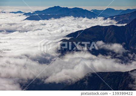 A view of the sea of clouds and the mountain range towards Zarugatake from Mt. Kannon in the Southern Alps, the Houou Sanzan mountain range. A view of the sea of clouds and the mountain range towards Zarugatake from Mt. Kannon in the Southern Alps, the Houou Sanzan mountain range. 139399422