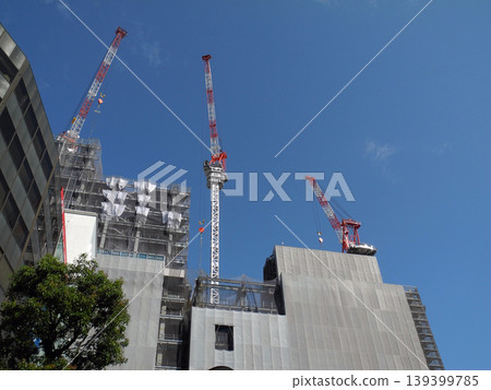 A tower crane at a building construction site against a blue sky. 139399785