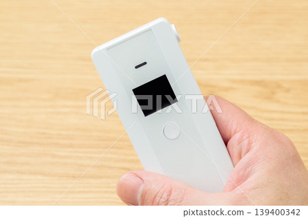 Alcohol tester held in the right hand Alcohol tester held in the right hand 139400342