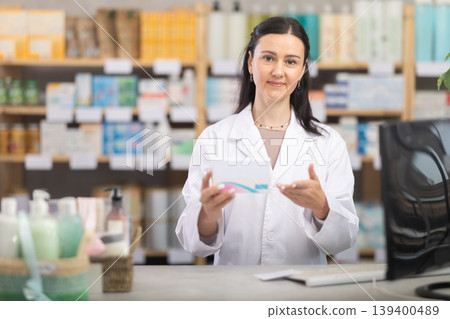 Female pharmacist offers pills and medicines to customers Female pharmacist offers pills and medicines to customers 139400489