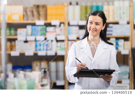 Female pharmacist holding tablet in her hands Female pharmacist holding tablet in her hands 139400519