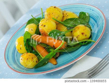 Delicious cooked fried new potatoes with spinach served at plate Delicious cooked fried new potatoes with spinach served at plate 139400855
