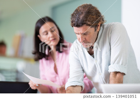 Man draws construction plan, woman gives document for review 139401051