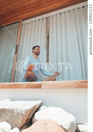 Caucasian man practicing yoga and meditation at home sitting on floor at terrace Caucasian man practicing yoga and meditation at home sitting on floor at terrace 139401213