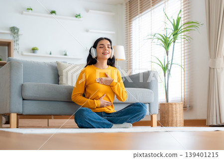 Happy young Asian woman practicing yoga and meditation at home Happy young Asian woman practicing yoga and meditation at home 139401215