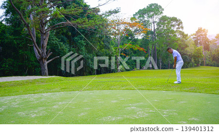 Golfers are putting golf in the evening golf course golf backglound. Golfers are putting golf in the evening golf course golf backglound. 139401312