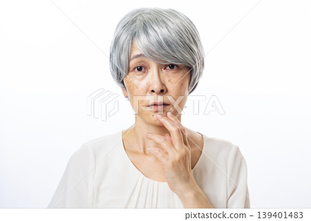 一位白髮蒼蒼的老婦人，眼中噙滿了淚水。 139401483