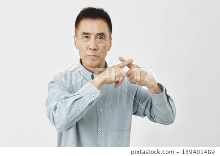 一名男子在白色背景前做出「X」形手勢。 139401489