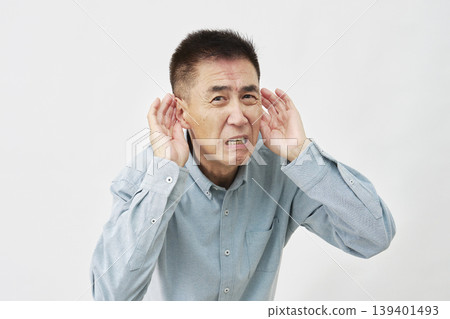 A man who is hard of hearing on a white background A man who is hard of hearing on a white background 139401493