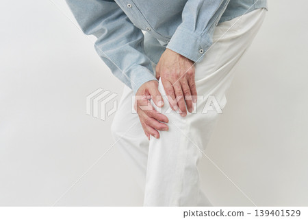 一位老年男子摀著膝蓋，背景為白色，臉部模糊不清。 139401529