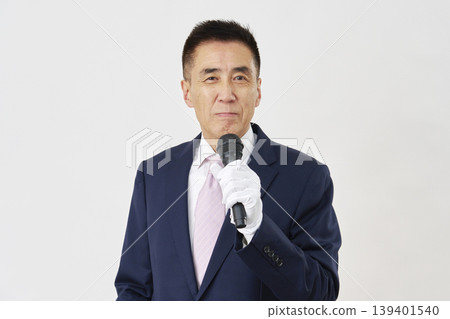 一位男性候選人面帶微笑，在白色背景前發表演說。 139401540