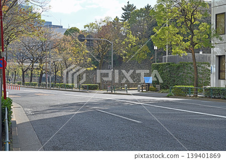 東京一橋的石牆與綠樹成蔭的街道:靠近皇宮,是歷史與現代和諧共存的寧靜都市街角。 東京一橋的石牆與綠樹成蔭的街道:靠近皇宮,是歷史與現代和諧共存的寧靜都市街角。 139401869