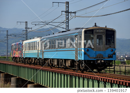 A three-car Kiha 54/32 series train running on the Yosan Line. 139401917