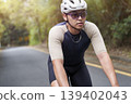 young asian male cyclist riding bicycle outdoors 139402043