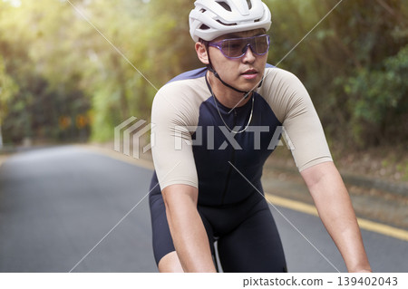 young asian male cyclist riding bicycle outdoors young asian male cyclist riding bicycle outdoors 139402043
