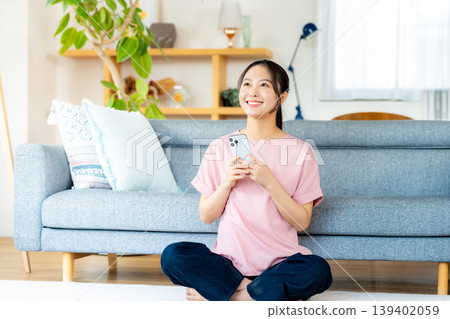 在房間裡操作智慧型手機的年輕女子 139402059