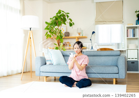在房間裡操作智慧型手機的年輕女子 139402265