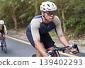 young asian male cyclist riding bicycle outdoors 139402293