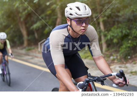 young asian male cyclist riding bicycle outdoors young asian male cyclist riding bicycle outdoors 139402293