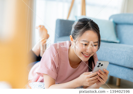 在房間裡操作智慧型手機的年輕女子 139402596