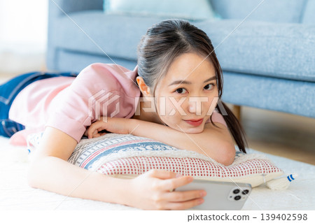在房間裡操作智慧型手機的年輕女子 139402598