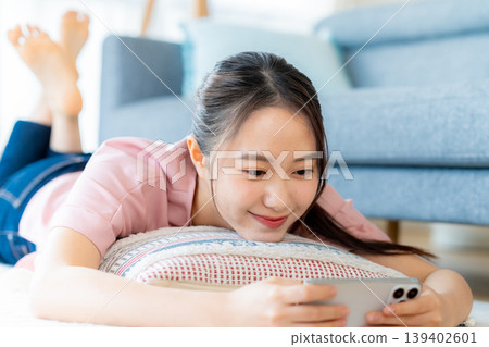 在房間裡操作智慧型手機的年輕女子 139402601