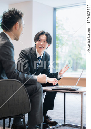 A business image of a sales representative conducting a business meeting in an office lounge. A business image of a sales representative conducting a business meeting in an office lounge. 139402761