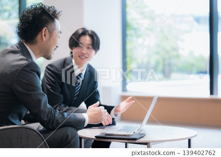 A business image of a sales representative conducting a business meeting in an office lounge. A business image of a sales representative conducting a business meeting in an office lounge. 139402762